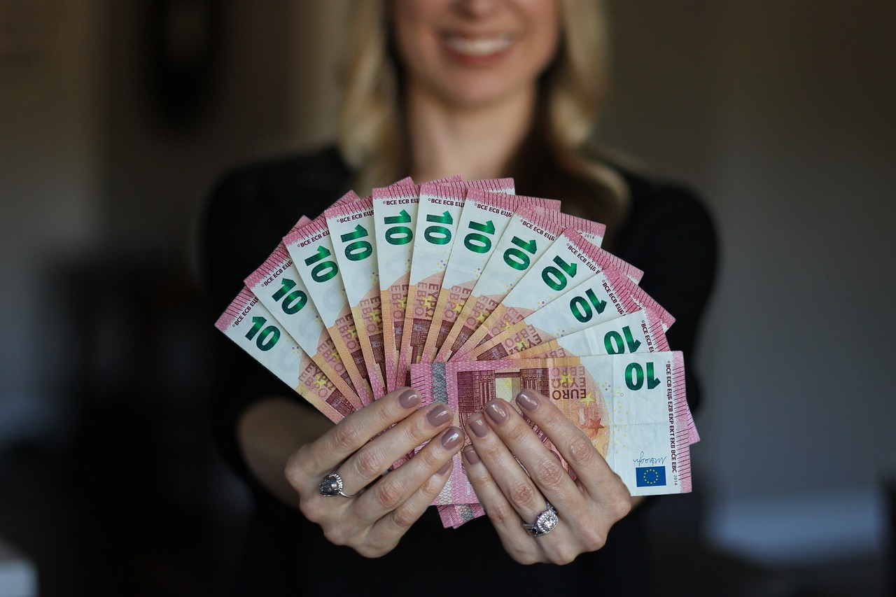 Frau hält Geldscheine in der Hand als Symbol für Affiliate Marketing und Reise Partnerprogramme